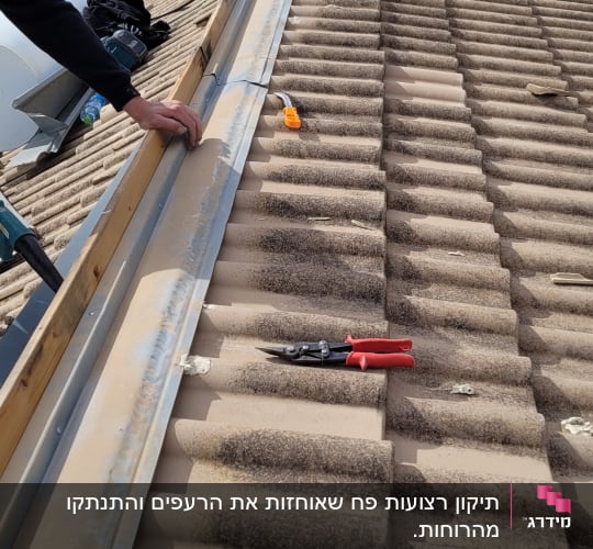 עבודת תיקון על גג רעפים עם כלי עבודה